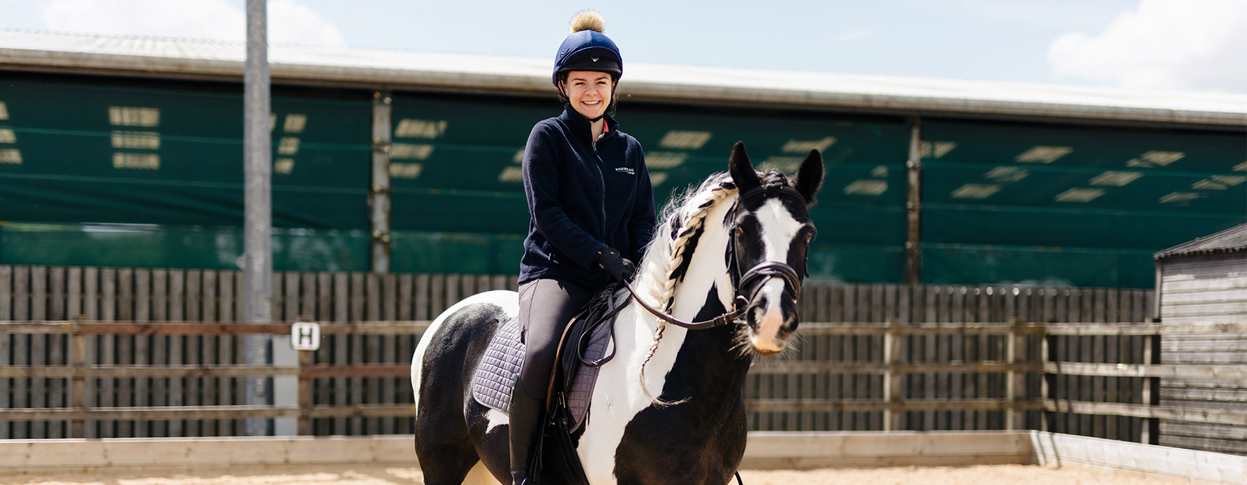 Equine student sat smiling on horse