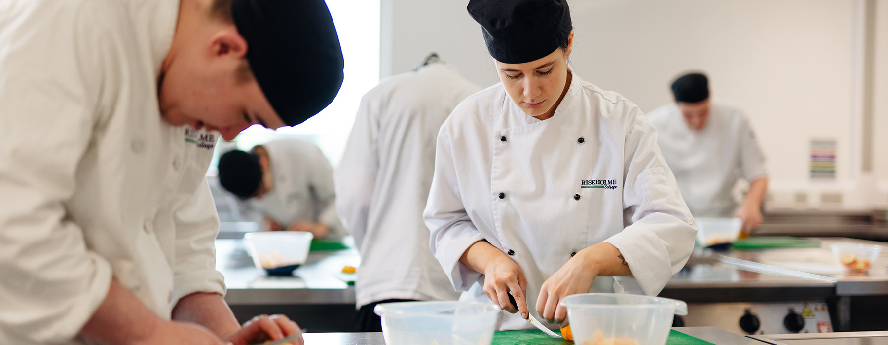Professional cookery students preparing vegetables