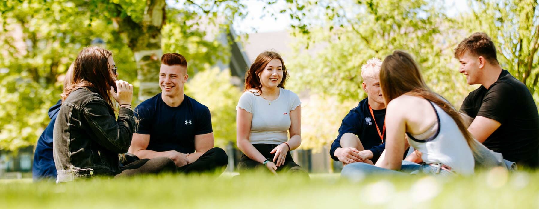 Students sat chatting on grass