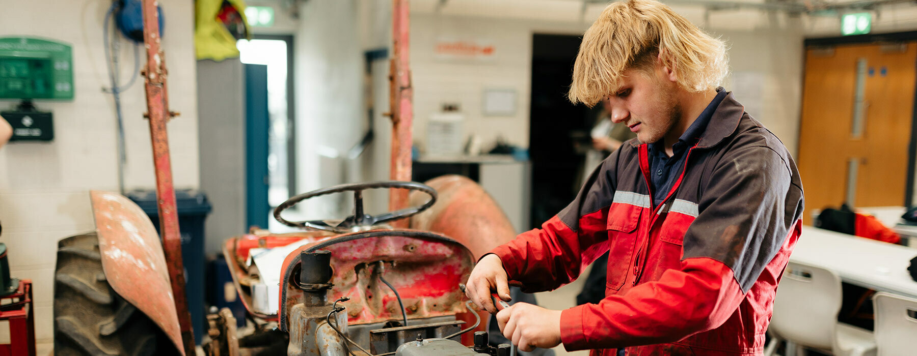 Apprenticeships banner Riseholme College Engineering student fixing red tractor