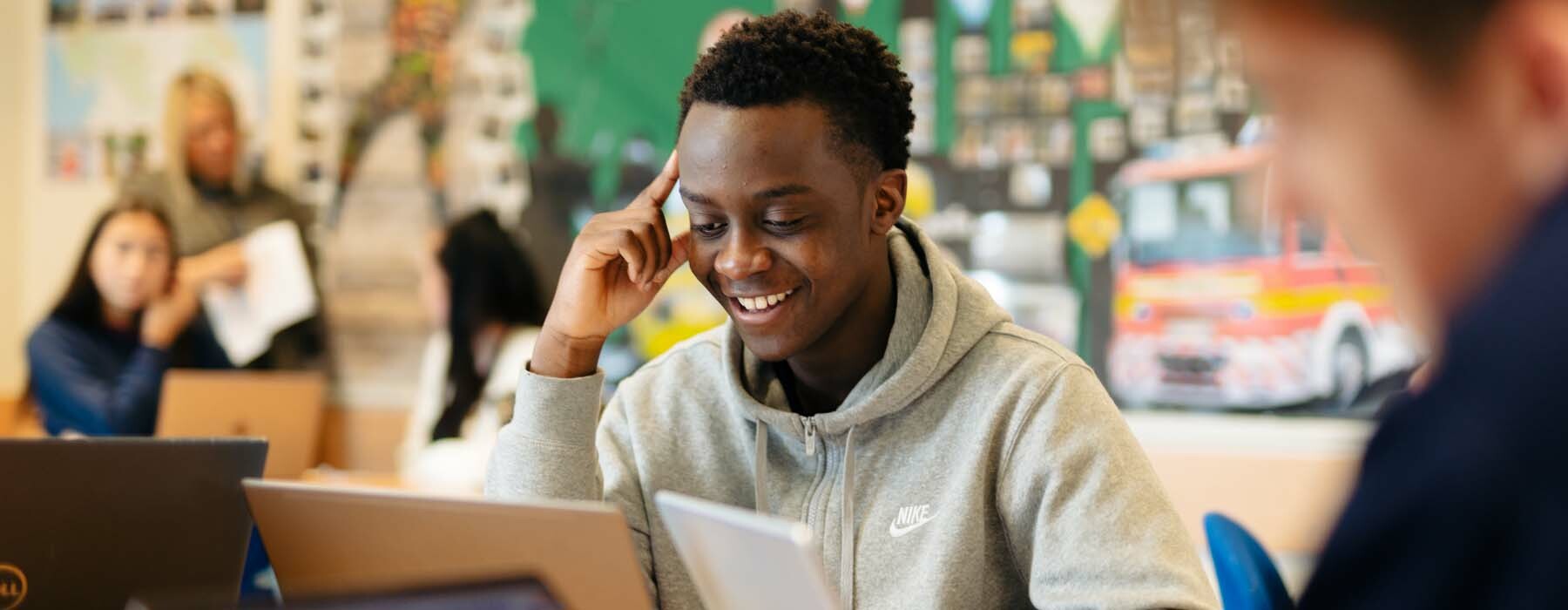 Business student works on laptop in classroom